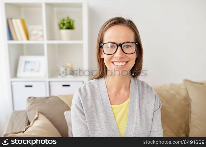 people, eyesight and vision concept - happy smiling middle-aged woman in eyeglasses at home. happy smiling woman in eyeglasses at home. happy smiling woman in eyeglasses at home
