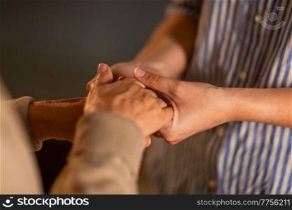 people, family and charity concept - close up of women holding hands. close up of women holding hands
