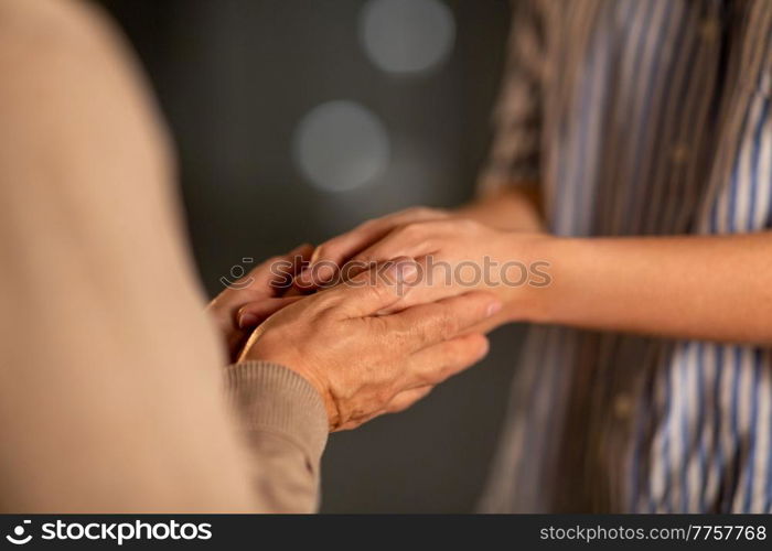 people, family and charity concept - close up of women holding hands. close up of women holding hands