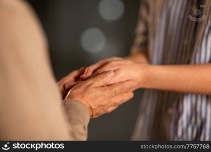 people, family and charity concept - close up of women holding hands. close up of women holding hands