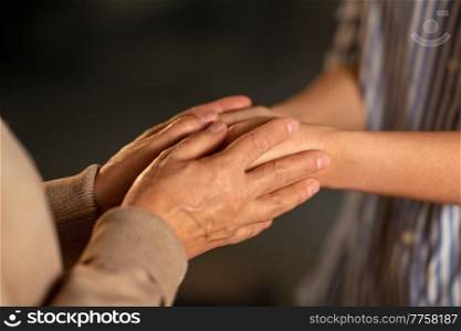 people, family and charity concept - close up of women holding hands. close up of women holding hands