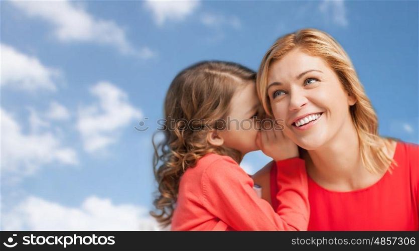 people, family and communication concept - happy mother and daughter whispering something into ear over blue sky background