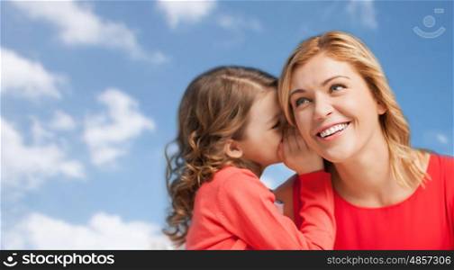 people, family and communication concept - happy mother and daughter whispering something into ear over blue sky background