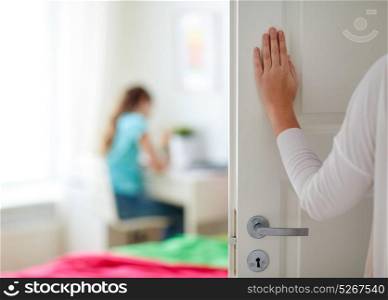 people, family and privacy concept - mother hand opening door to girl room. mother hand opening door to girl room