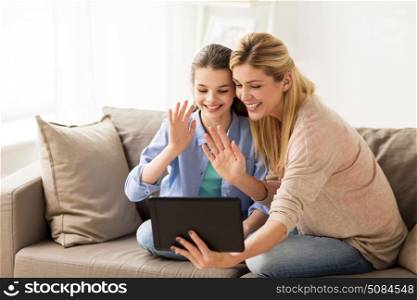 people, family and technology concept - happy girl and mother with tablet pc computer at home. happy family with tablet pc at home. happy family with tablet pc at home
