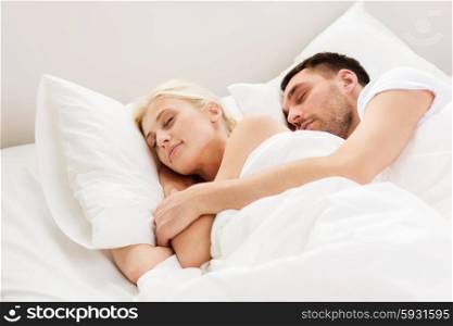 people, family, bedtime and happiness concept - happy couple sleeping and hugging in bed at home