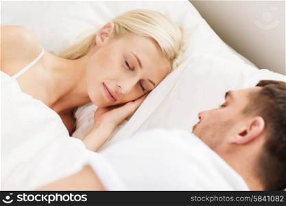people, family, bedtime and happiness concept - happy couple sleeping in bed at home