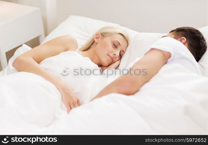 people, family, bedtime and happiness concept - happy couple sleeping in bed at home