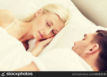 people, family, bedtime and happiness concept - happy couple sleeping in bed at home