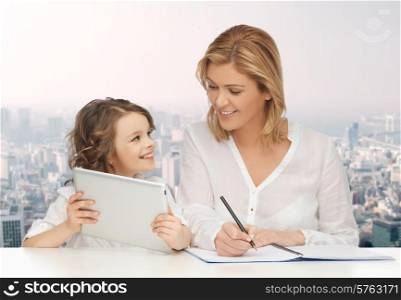 people, family, home education, children and technology concept - happy mother and daughter with tablet pc and notebook over city background