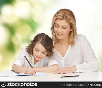 people, family, school, home education and parenting concept -happy mother and daughter doing homework and writing in notebook over green background