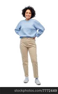 people, fashion and style concept - happy smiling woman in blue sweater and jeans over white background. happy smiling woman in blue sweater and jeans