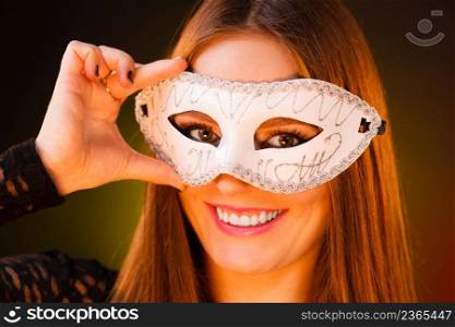 People, fashion, party concept. Sensual woman with carnival mask. Attractive young lady with long brown hair preaparing for celebration.. Sensual woman with carnival mask.