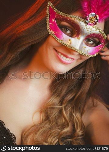 People, fashion, party concept. Sensual woman with carnival mask. Attractive young lady with long brown hair preaparing for celebration.. Sensual woman with carnival mask.