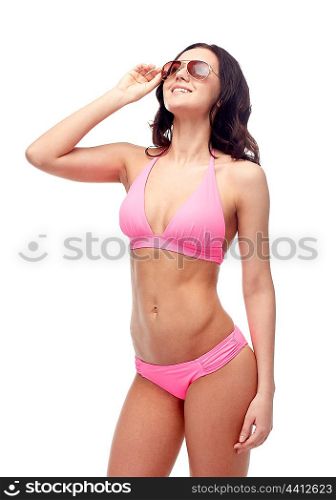 people, fashion, swimwear, summer and beach concept - happy young woman in sunglasses and pink swimsuit looking up