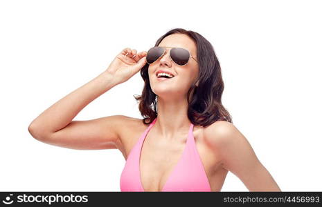 people, fashion, swimwear, summer and beach concept - happy young woman in sunglasses and pink bikini swimsuit