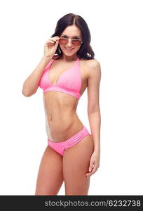 people, fashion, swimwear, summer and beach concept - happy young woman in sunglasses and pink swimsuit looking at you