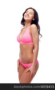 people, fashion, swimwear, summer and beach concept - happy young woman in pink bikini swimsuit