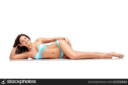 people, fashion, swimwear, summer and beach concept - happy young woman lying in bikini swimsuit