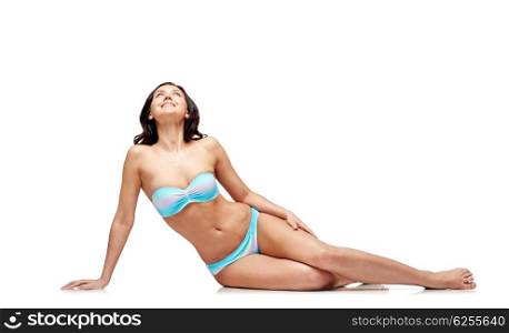 people, fashion, swimwear, summer and beach concept - happy young woman sunbathing in bikini swimsuit and looking up