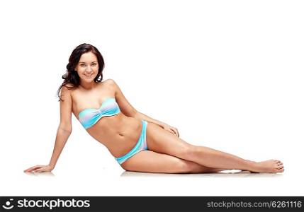 people, fashion, swimwear, summer and beach concept - happy young woman sunbathing in bikini swimsuit