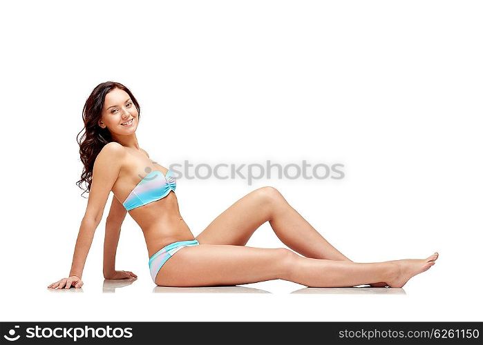 people, fashion, swimwear, summer and beach concept - happy young woman sunbathing in bikini swimsuit