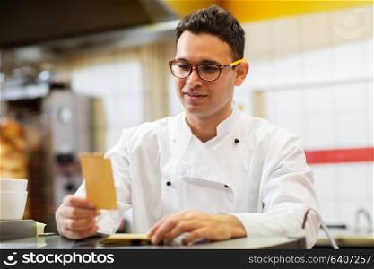 people, fast food and cooking concept - chef at kebab shop with order or paper note. chef at kebab shop with order or paper note