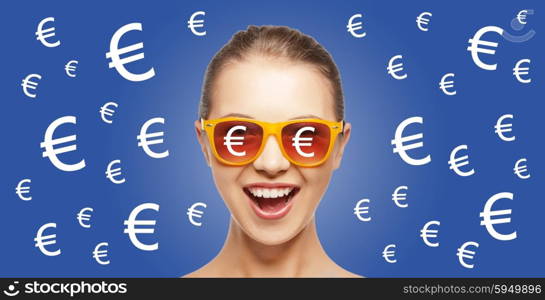 people, finance and money concept - happy screaming teenage girl in shades over blue background with euro currency sings