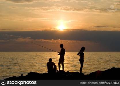 People fish. The sea, evening, the beautiful sky.