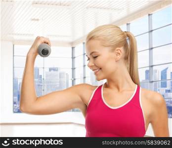 people, fitness and sport concept - close up of happy young woman flexing her biceps over gym or home background
