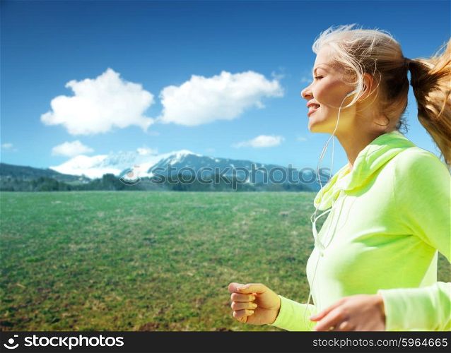 people, fitness, sport and healthy lifestyle concept - happy sporty woman running or jogging over nature