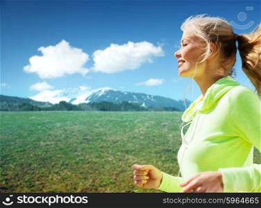 people, fitness, sport and healthy lifestyle concept - happy sporty woman running or jogging over nature