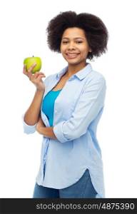 people, food, healthy eating and dental care concept - happy african american young woman with green apple