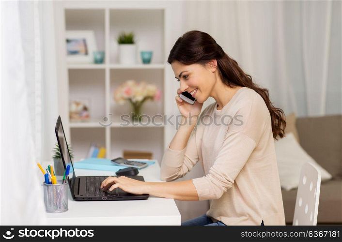 people, freelance and education concept - happy smiling woman with laptop computer working and calling on smartphone at home. woman with laptop calling on smartphone at home