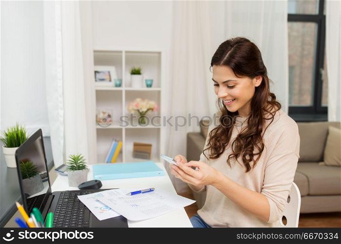 people, freelance and education concept - happy smiling woman with papers and smartphone working at home. woman with papers and smartphone working at home. woman with papers and smartphone working at home