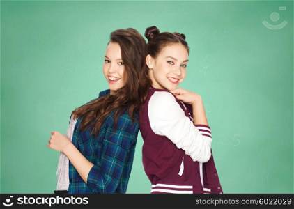 people, friends, teens and education concept - happy smiling pretty teenage girls over green school chalk board background