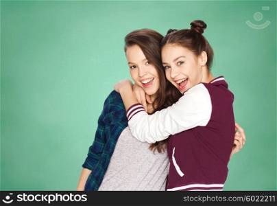 people, friends, teens and education concept - happy smiling pretty teenage girls hugging over green school chalk board background