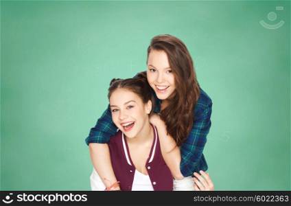 people, friends, teens and education concept - happy smiling pretty teenage girls having fun over green school chalk board background
