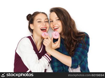 people, friends, teens and friendship concept - happy smiling pretty teenage girls with donuts eating and having fun