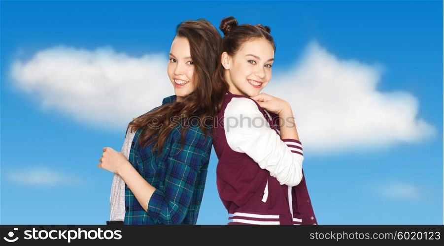 people, friends, teens and friendship concept - happy smiling pretty teenage girls over blue sky and clouds background