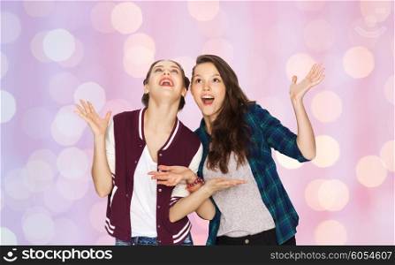 people, friends, teens and friendship concept - happy smiling pretty teenage girls hugging over pink holidays lights background