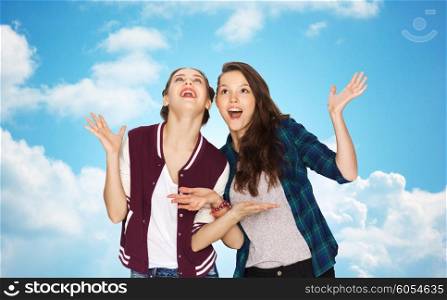 people, friends, teens and friendship concept - happy smiling pretty teenage girls hugging over blue sky and clouds background