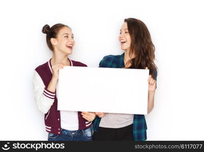 people, friends, teens and friendship concept - happy smiling pretty teenage girls holding and showing white blank board