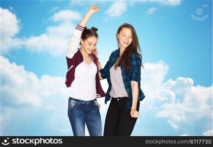 people, friends, teens and friendship concept - happy smiling pretty teenage girls dancing over blue sky and clouds background