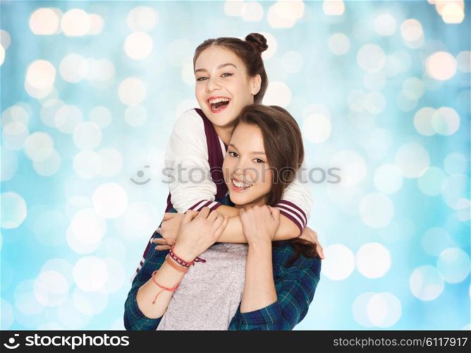 people, friends, teens and friendship concept - happy smiling pretty teenage girls hugging over blue holidays lights background