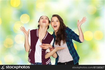people, friends, teens and friendship concept - happy smiling pretty teenage girls hugging over green holidays lights background