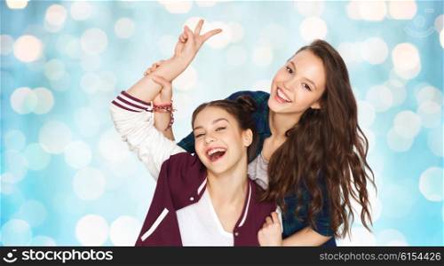 people, friends, teens and friendship concept - happy smiling pretty teenage girls showing peace hand sign over blue holidays lights background