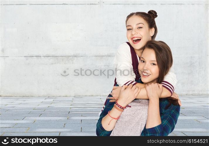 people, friends, teens and friendship concept - happy smiling pretty teenage girls hugging over gray urban street background