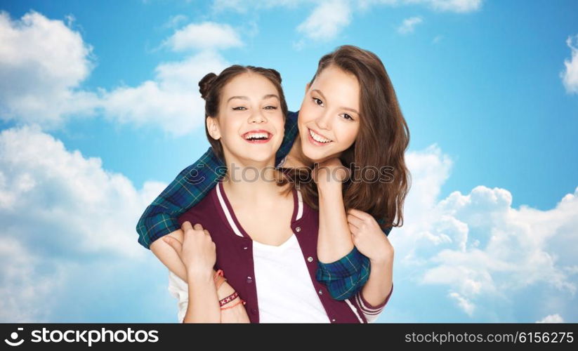 people, friends, teens and friendship concept - happy smiling pretty teenage girls hugging over blue sky and clouds background