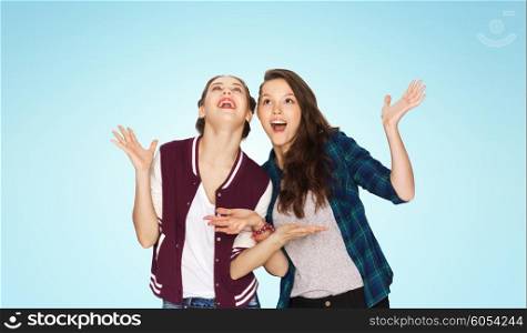 people, friends, teens and friendship concept - happy smiling pretty teenage girls hugging over blue background